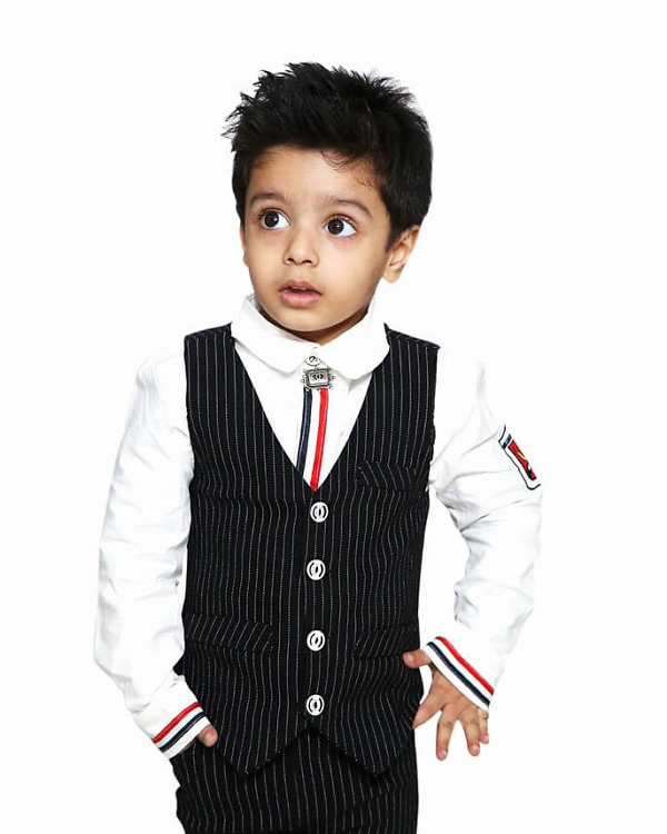 Stylish baby boy birthday outfit with white shirt black trousers and waistcoat, festive wear